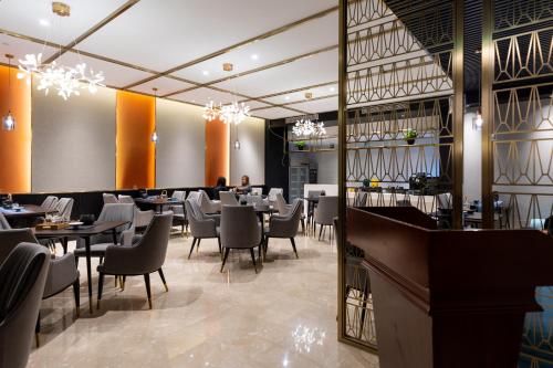 a restaurant with tables and chairs and a bar at Dijon Hotel Shanghai in Shanghai