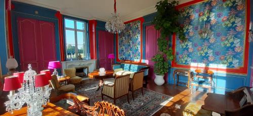 - un salon avec des murs rouges et bleus dans l'établissement Le Château du Breuil, à Mazières-de-Touraine