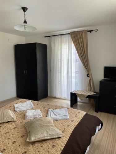 a bedroom with a bed with two pillows and a window at Casa Anastasia - Moieciu de Sus in Moieciu de Sus