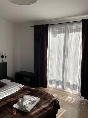 a bedroom with a bed and a large window at Casa Anastasia - Moieciu de Sus in Moieciu de Sus
