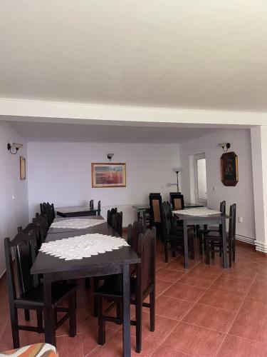 a dining room with tables and chairs in a room at Casa Anastasia - Moieciu de Sus in Moieciu de Sus