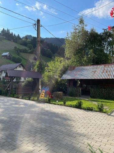 a brick road next to a house and a building at Casa Anastasia - Moieciu de Sus in Moieciu de Sus
