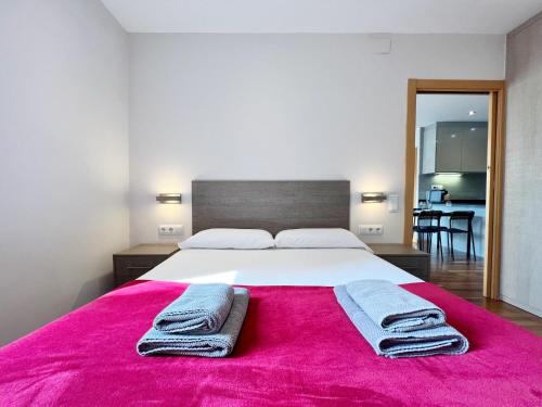a bedroom with a large white bed with a pink blanket at Teatro Miro Apartment in Barcelona