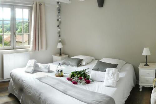 - un lit blanc orné de fleurs dans la chambre dans l'établissement Orée de Marmeloux, à Sainte-Catherine