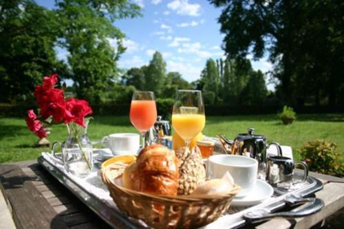 - une table avec un panier de nourriture et des verres de jus d'orange dans l'établissement Orée de Marmeloux, à Sainte-Catherine