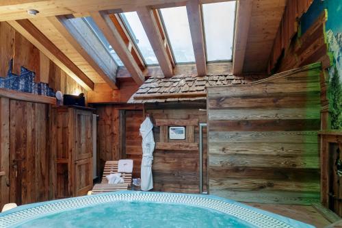 bañera en una habitación con paredes de madera en Matterhorn Retreat Francois - Camere in centro Cervina con Colazione, Accesso SPA e WiFi, en Breuil-Cervinia