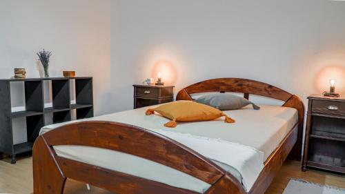 1 dormitorio con 1 cama de madera y 2 mesitas de noche en Lidia Apartment, en Cluj-Napoca
