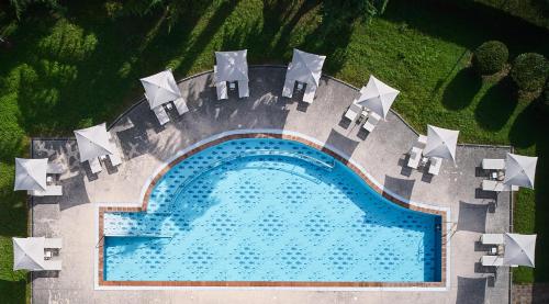 uma vista superior de uma piscina com mesas e cadeiras em Delfina Palace Hotel em Foligno