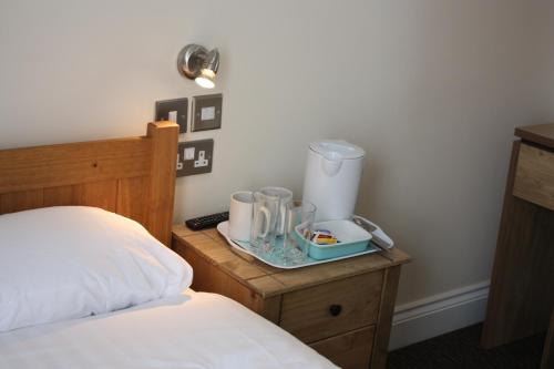 a bedroom with a bed and a nightstand with a table with a blender at Earls Court Garden Hotel in London