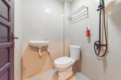 La salle de bains est pourvue de toilettes et d'un lavabo. dans l'établissement Urbanview Hotel Diamond Malai Permata near Universitas Palangkaraya, à Palangka Raya