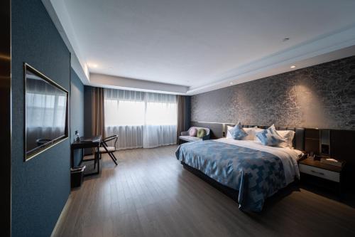 a hotel room with a bed and a desk at Dijing Hotel Shanghai in Shanghai