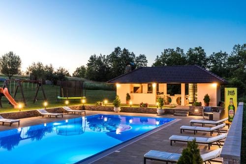 una piscina con parque infantil y una casa en Apartments Lucija, en Slunj