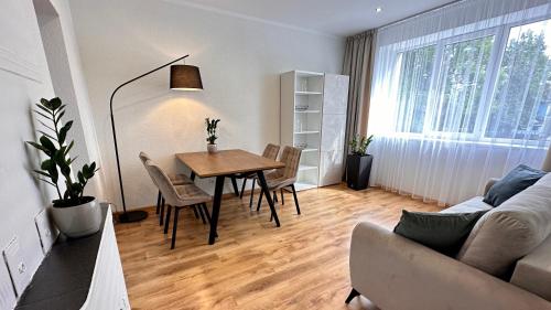 sala de estar con mesa, sillas y sofá en LILLE`S apartment in city center, en Alūksne
