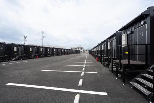 een lange lijn van treinwagons geparkeerd op een parkeerplaats bij HOTEL R9 The Yard Iwakuni in Iwakuni