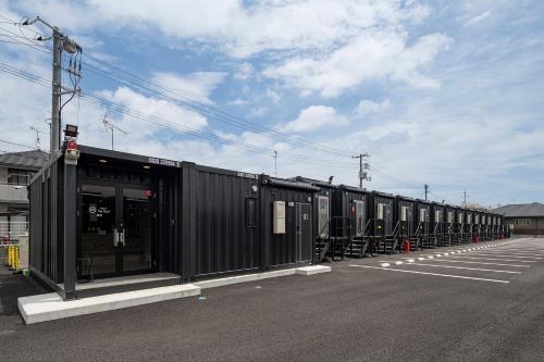 a row of train cars parked in a parking lot at HOTEL R9 The Yard Iwakuni in Iwakuni