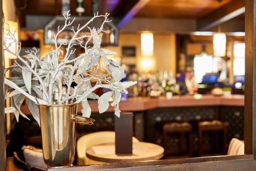 a vase of flowers on a table in a bar at Hotelpark der Westerwald Treff in Oberlahr