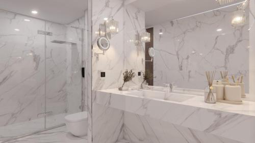 a white bathroom with a sink and a toilet at AlHamra Hotel Kuwait in Kuwait