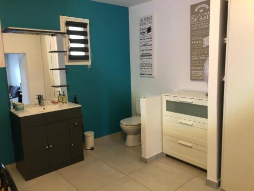 La salle de bains est pourvue de toilettes et d'un mur bleu. dans l'établissement La Casa V Chambre et salon privé en Provence, à Châteaurenard