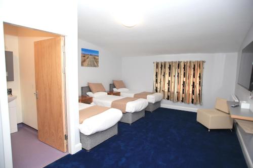 a room with three beds and a tv in it at Home Inn in Athlone