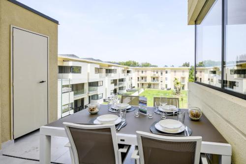 una mesa de comedor en un balcón con vistas a un edificio en Katya Resort Superior Apartments - MGH en Desenzano del Garda