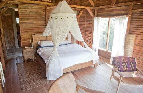 sypialnia z łóżkiem z baldachimem w drewnianym domku w obiekcie Master bed room inBukit Cottage Pak Ansel 