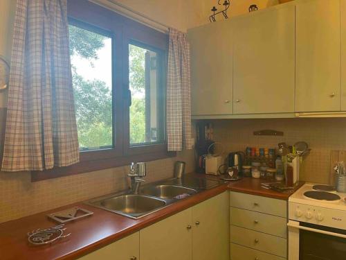 a kitchen with a sink and a window in it at Souda’s nest in Plakias