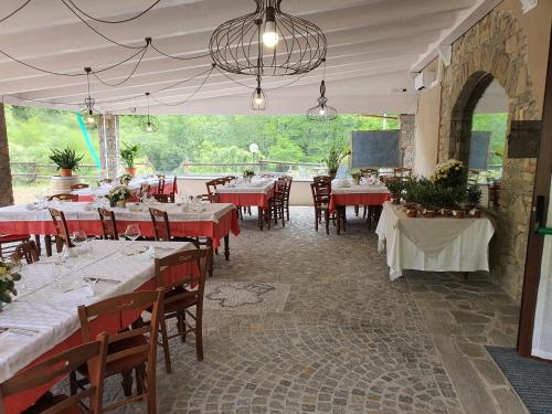 a dining room with tables and chairs in a restaurant at Agriturismo Cascina L'Arché in Santo Stefano Belbo