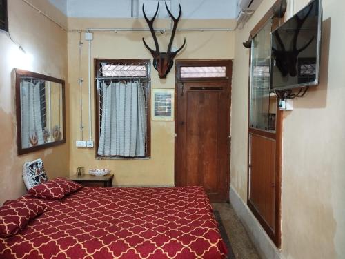 a bedroom with a bed and antlers on the wall at Divine view - Ac room for 2 pax - Swarna Bhavan in Puri