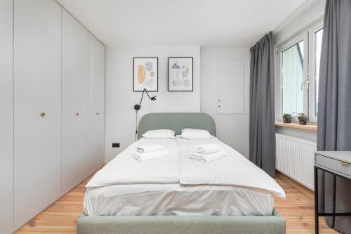 een witte slaapkamer met een groot bed. bij Walecznych 51 by Homeprime in Warschau