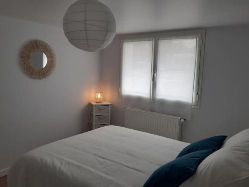 1 dormitorio con cama, espejo y ventana en Appartement neuf et cosy, en Cambo-les-Bains