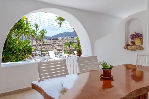 a dining room with a table and a large window at Afroditi Ftelia Yasemi b in Elia