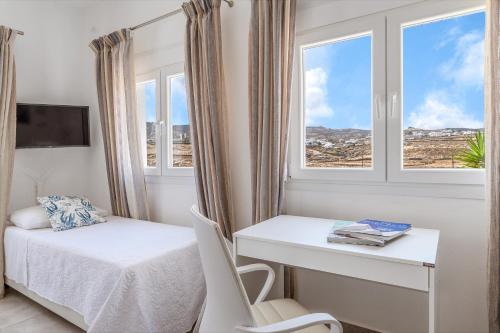 a bedroom with a bed and a desk and window at Afroditi Ftelia Anemone in Elia