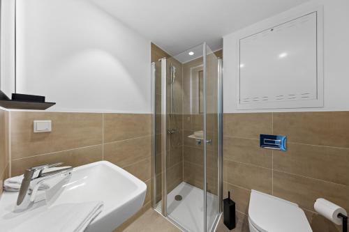 a bathroom with a shower and a sink and a toilet at Nena Apartments Berlin Adlershof in Berlin