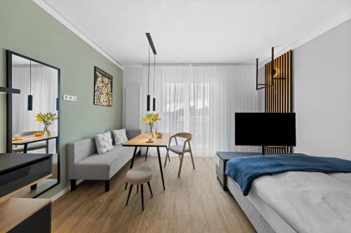 a bedroom with a bed and a table and a couch at Nena Apartments Berlin - Adlershof - "New Opening 2024" in Berlin