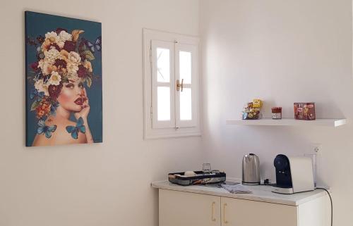 a kitchen with a table and a picture of a woman at Octopus Suites Parikia in Parikia