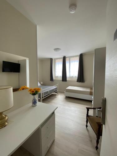 a large white room with a bed and a desk at Albergo Lodrino in Villa