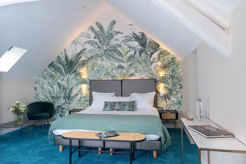 a bedroom with a green bed with a tropical wallpaper at Domaine et Golf de Vaugouard - La Maison Younan in Fontenay-sur-Loing