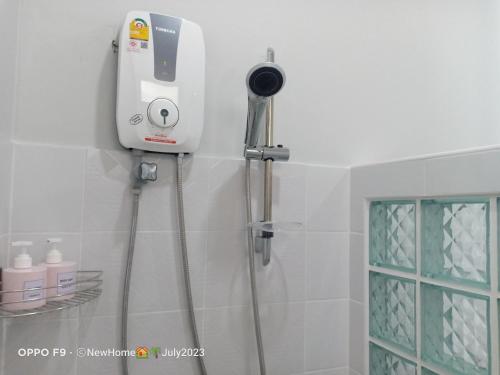 uma câmara na parede de um chuveiro na casa de banho em Min House em Lamphun