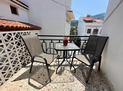 d'une petite table et de deux chaises sur un balcon. dans l'établissement Samos - Kokkari - Eirini's Studios, à Kokkari