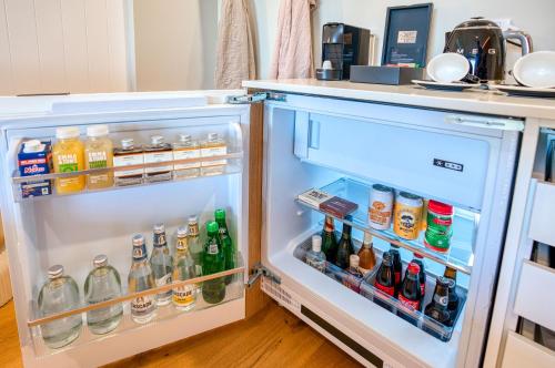 an open refrigerator filled with lots of drinks at Essence Peregian Beach in Peregian Beach