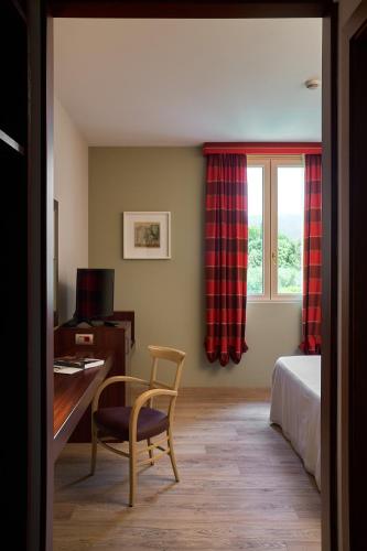 a bedroom with a desk and a bed and a window at Delfina Palace Hotel in Foligno