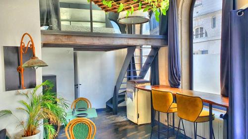 une pièce avec une table, des chaises et un escalier dans l'établissement Loft Zen Rouen - Jacuzzi - Centre Historique, à Rouen