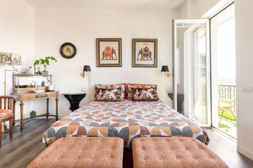 ein Schlafzimmer mit einem großen Bett mit zwei Ottomanen in der Unterkunft Eleventh Floor Suites in Cagliari
