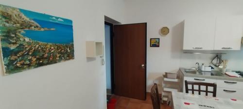 een keuken met een tafel en een wastafel en een schilderij aan de muur bij Mondello Blue Sea in Mondello
