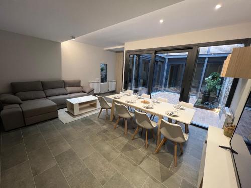 a living room with a table and chairs and a couch at Cal Teca Rural in Sant Antolí i Vilanova