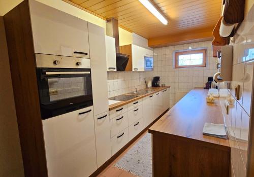 cocina con electrodomésticos blancos y techo de madera en Ferienwohnung Strohmaier, en Kitzeck im Sausal