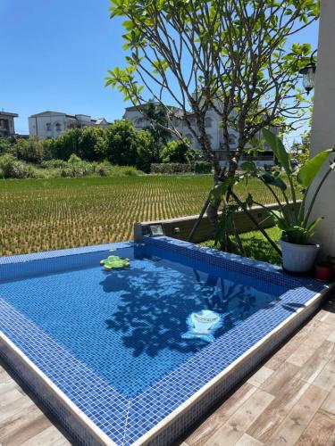 uma piscina com uma árvore ao fundo em Rambling Snail em Luodong