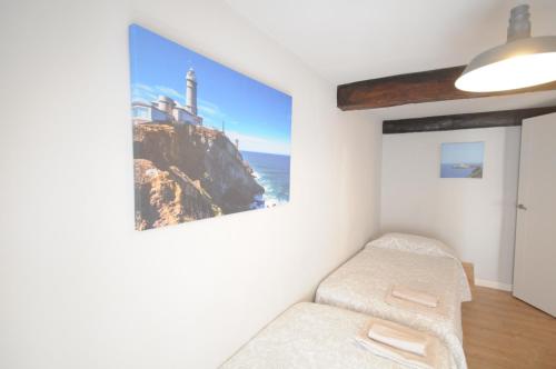 a room with a bed and a picture of a lighthouse at Apartamento con encanto 2 hab céntrico-ayuntamiento in Santander