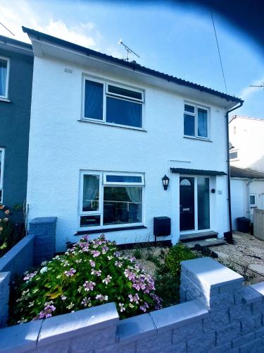 a white house with flowers in front of it at 'Serenity in Somerset ' Self Catering House Rental Near Chard , Accomodation for Contract Workers only in Chardstock