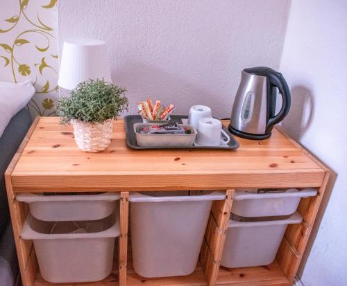 a wooden table with a tea kettle and a plant on it at Artsy Room for 2 in Prenzlauer Berg - Ideal Stay in Shared Flat in Berlin